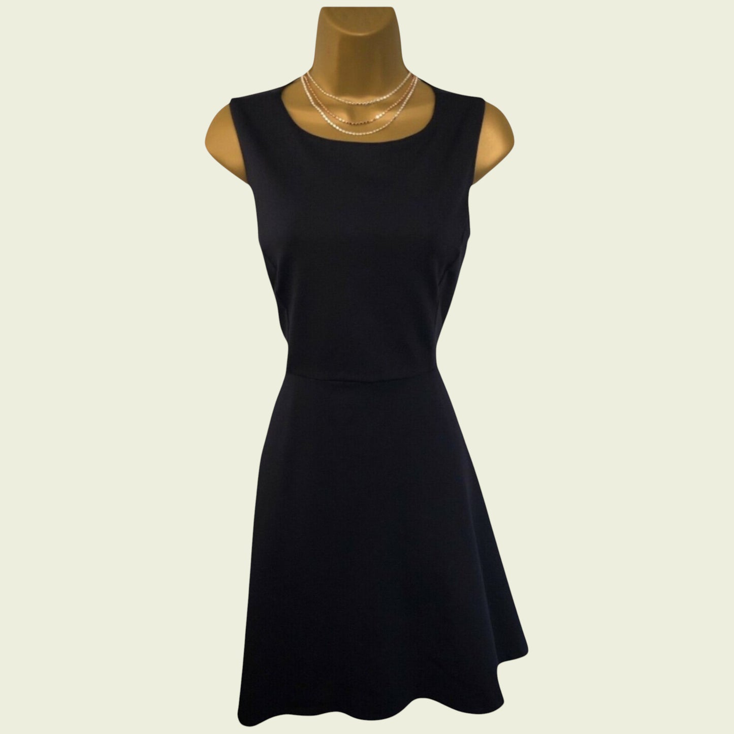 Black dress on a mannequin with a plain background