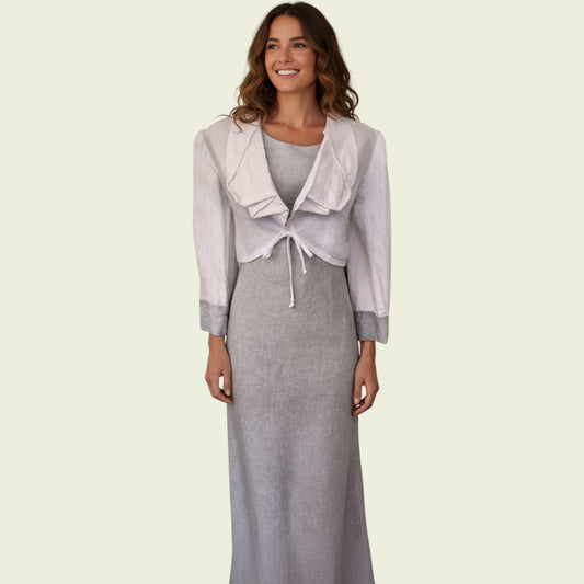 Woman wearing a gray dress with a matching jacket on a beige background