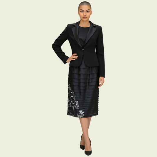 Woman wearing a black suit with an embroidered skirt on a beige background