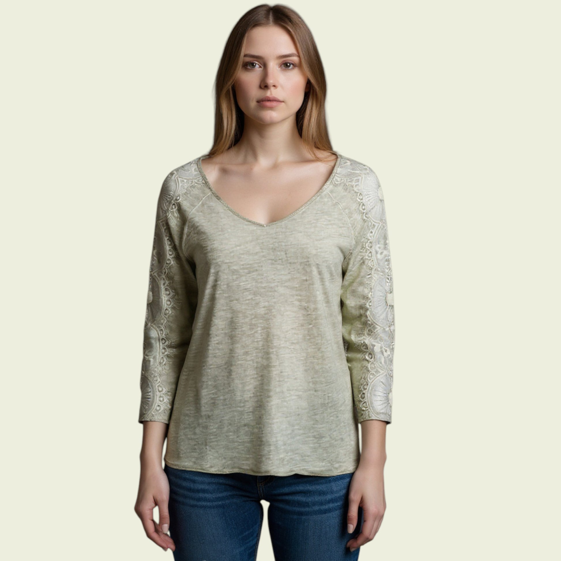 Woman wearing a light green long-sleeve top with lace sleeves on a beige background