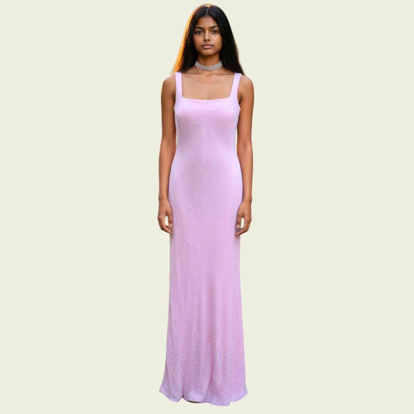 Woman wearing a long pink dress on a light beige background