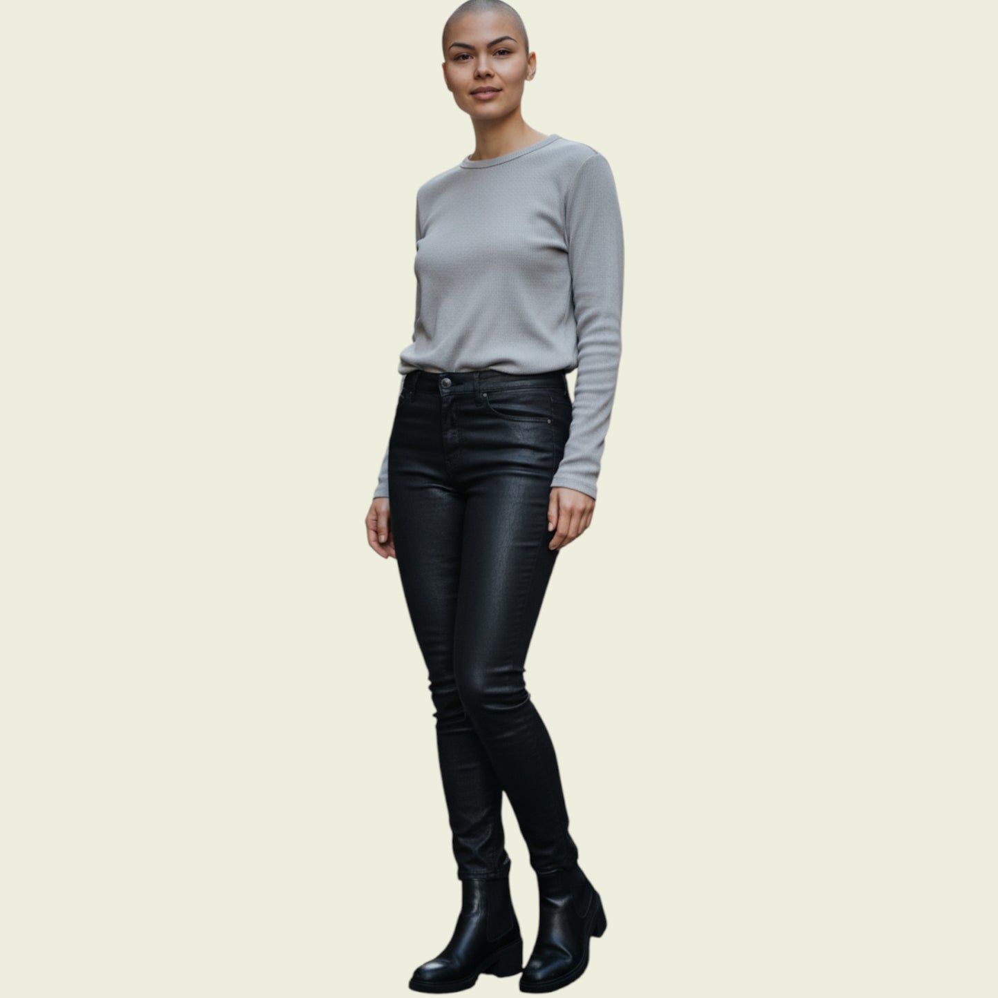 Person wearing a gray sweater and black leather pants on a beige background