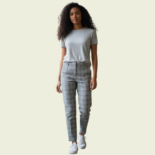 Woman wearing a gray t-shirt and plaid pants on a beige background