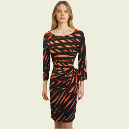 Woman wearing a black and orange patterned dress on a beige background