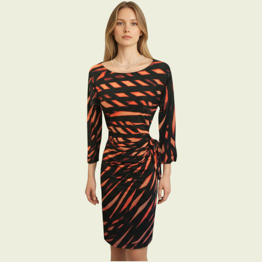 Woman wearing a black and orange patterned dress on a beige background