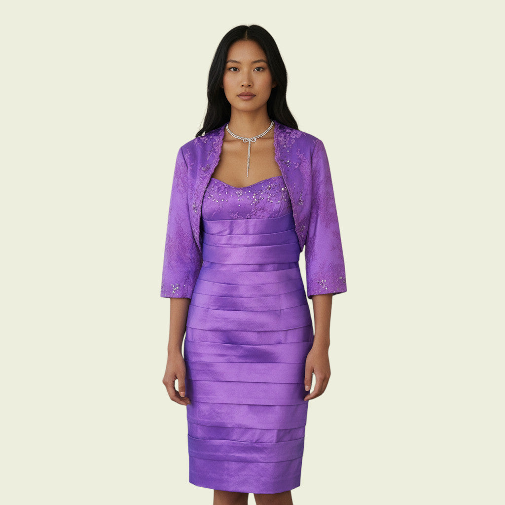 Woman wearing a purple dress with a matching jacket on a beige background