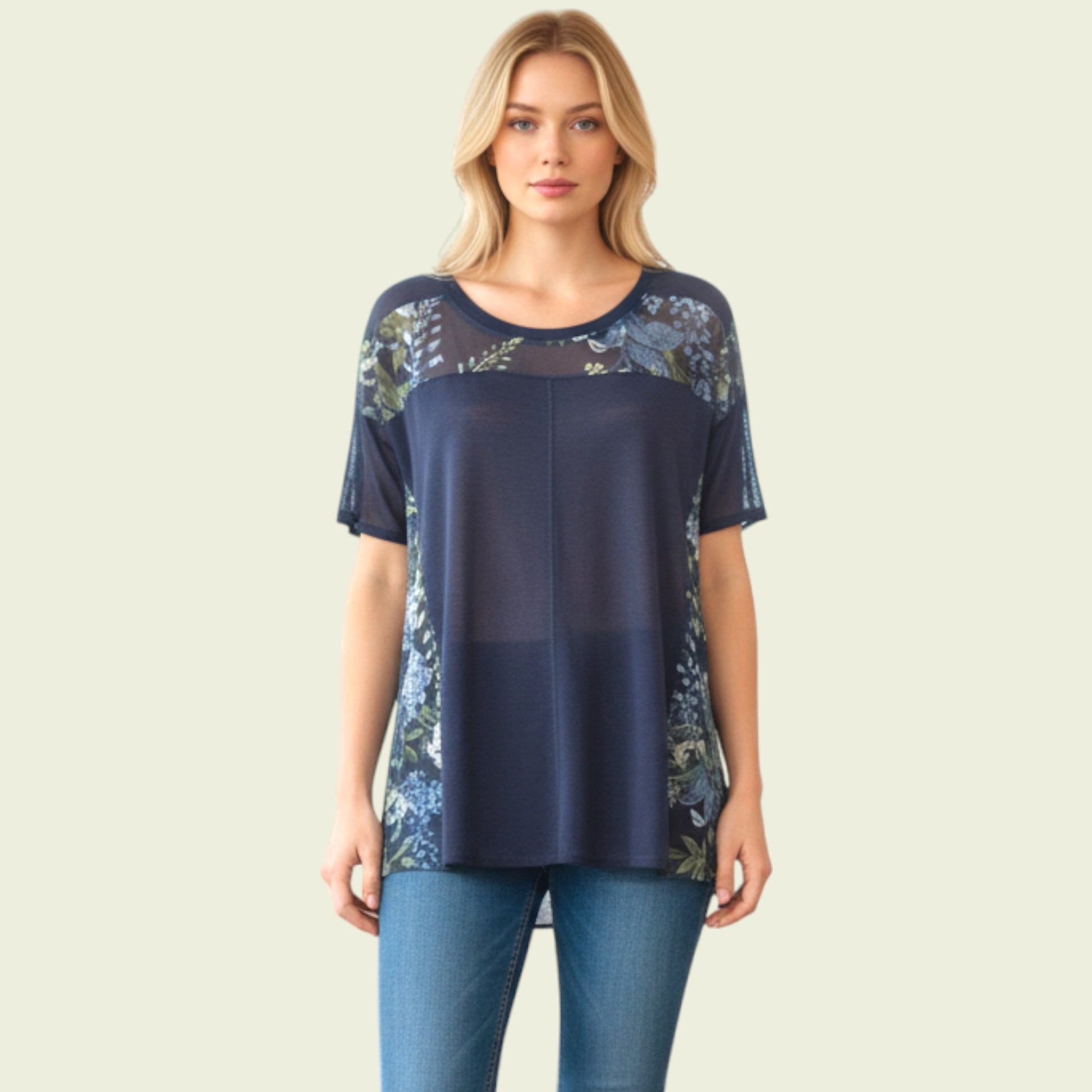 Woman wearing a navy blue top with floral lace details on a beige background