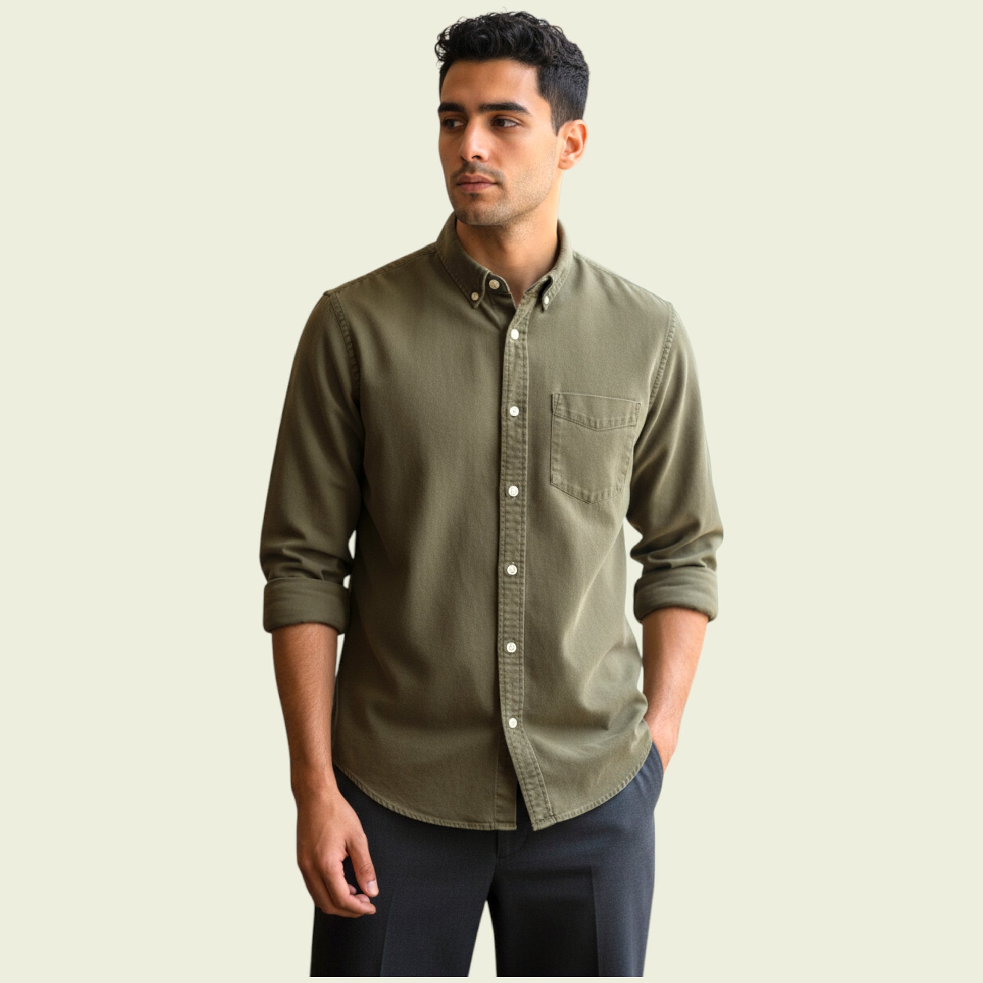 Man wearing a green button-up shirt against a beige background