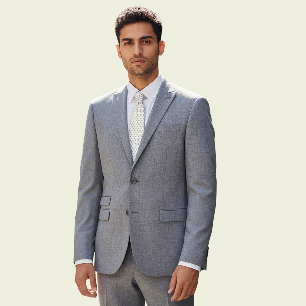 Man wearing a gray jacket with a white shirt and patterned tie on a light beige background