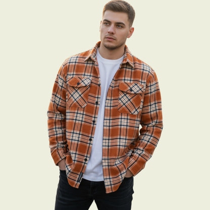 Man wearing a plaid shirt over a white t-shirt on a beige background