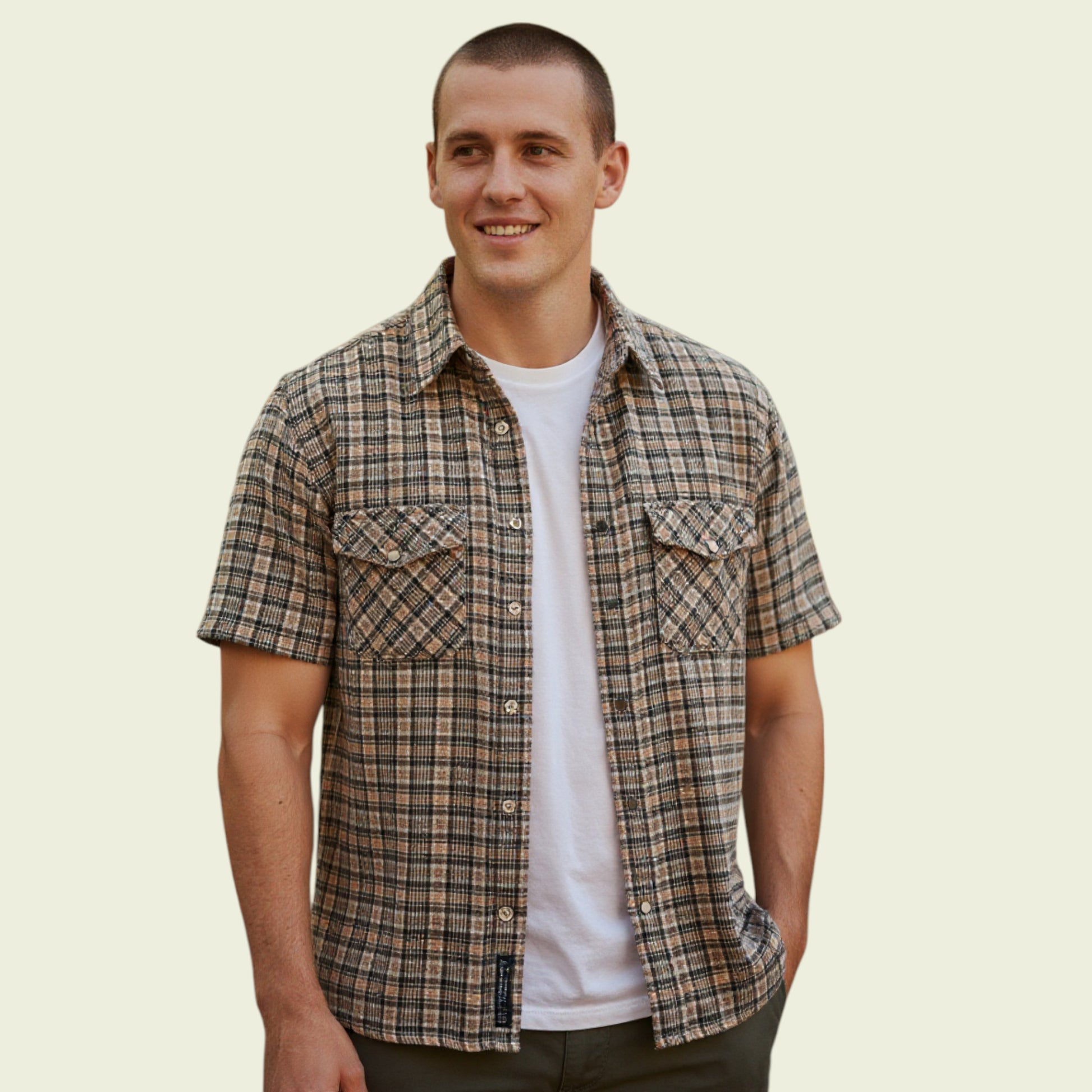Model wearing brown check shirt on a beige background