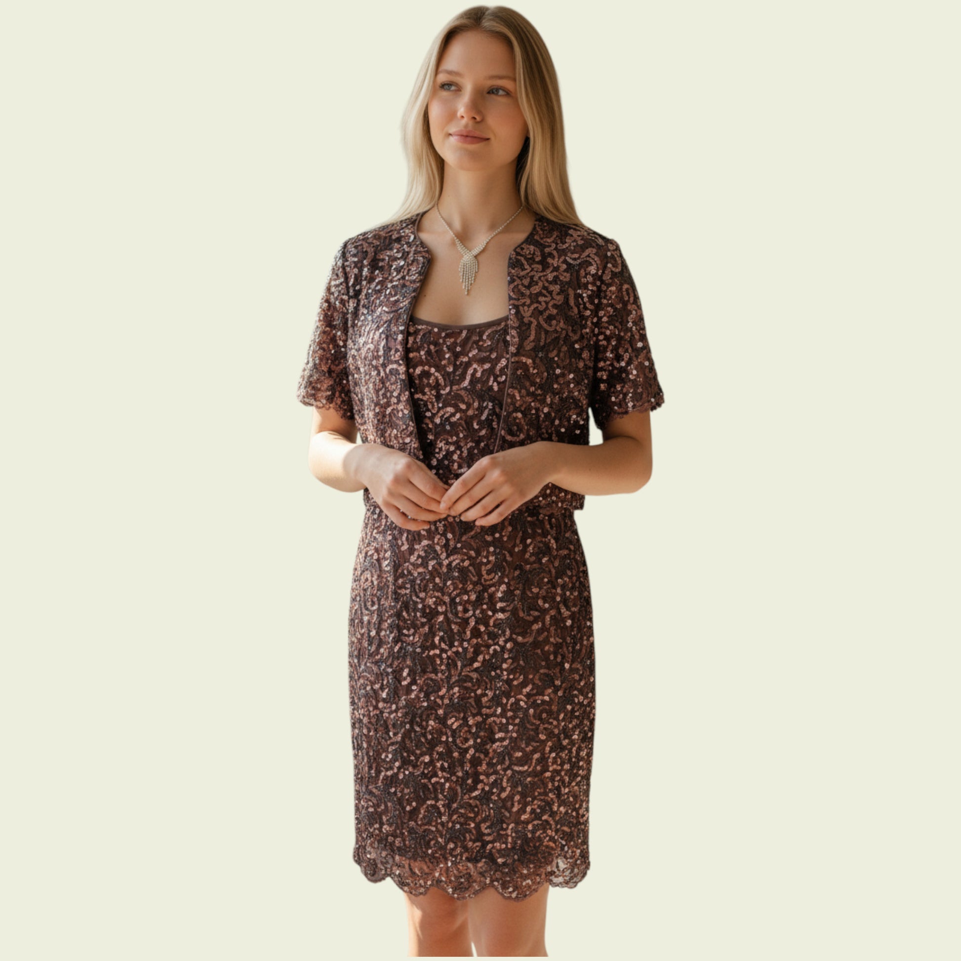 Woman wearing a sequinned dress and jacket set on a beige background