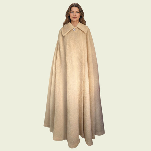 Woman wearing a beige cape on a light beige background