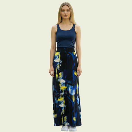 Woman wearing a navy tank top and a long, dark blue floral skirt on a beige background