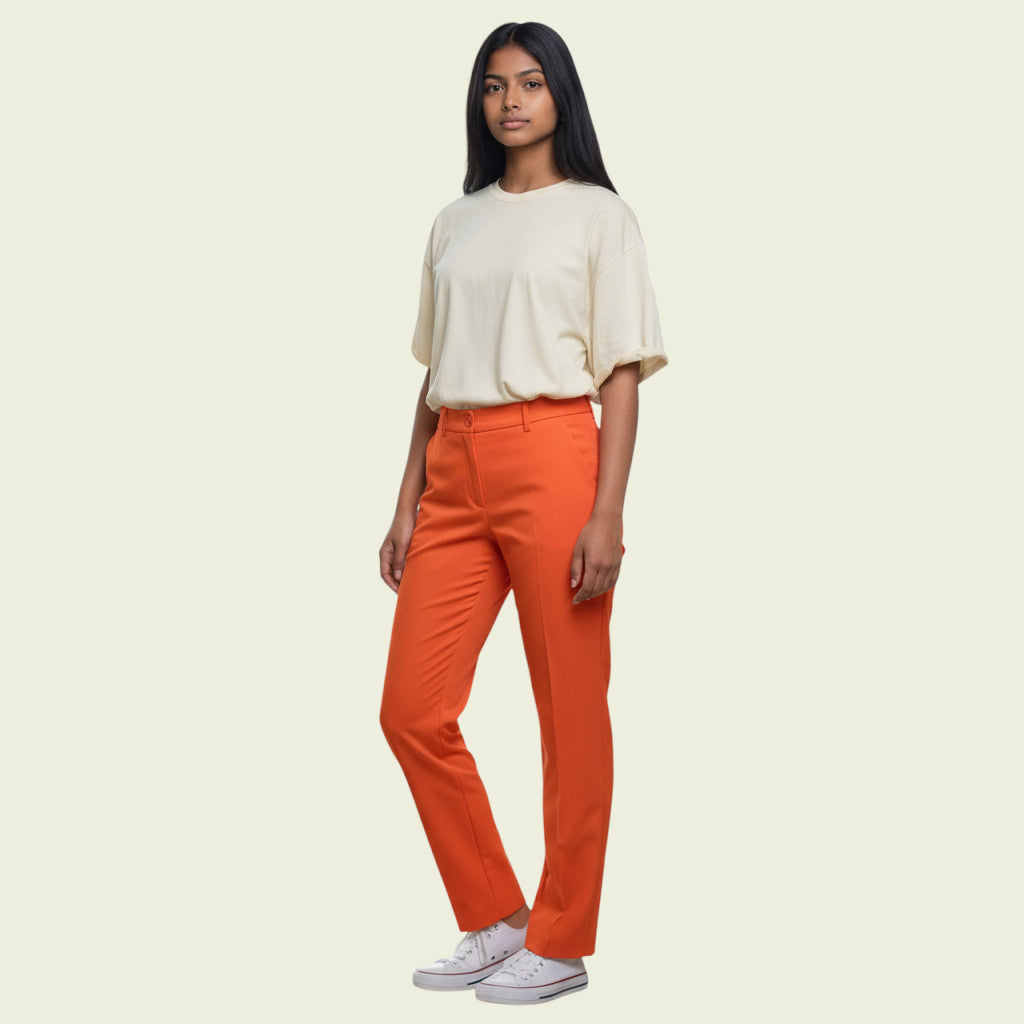 Woman wearing a white top and orange pants on a beige background