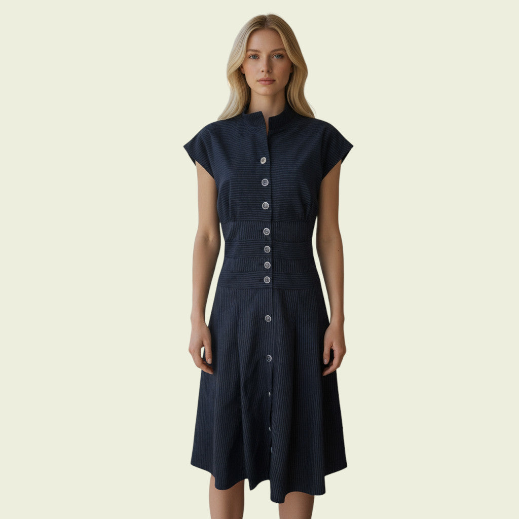 Woman wearing a navy dress with buttons on a beige background
