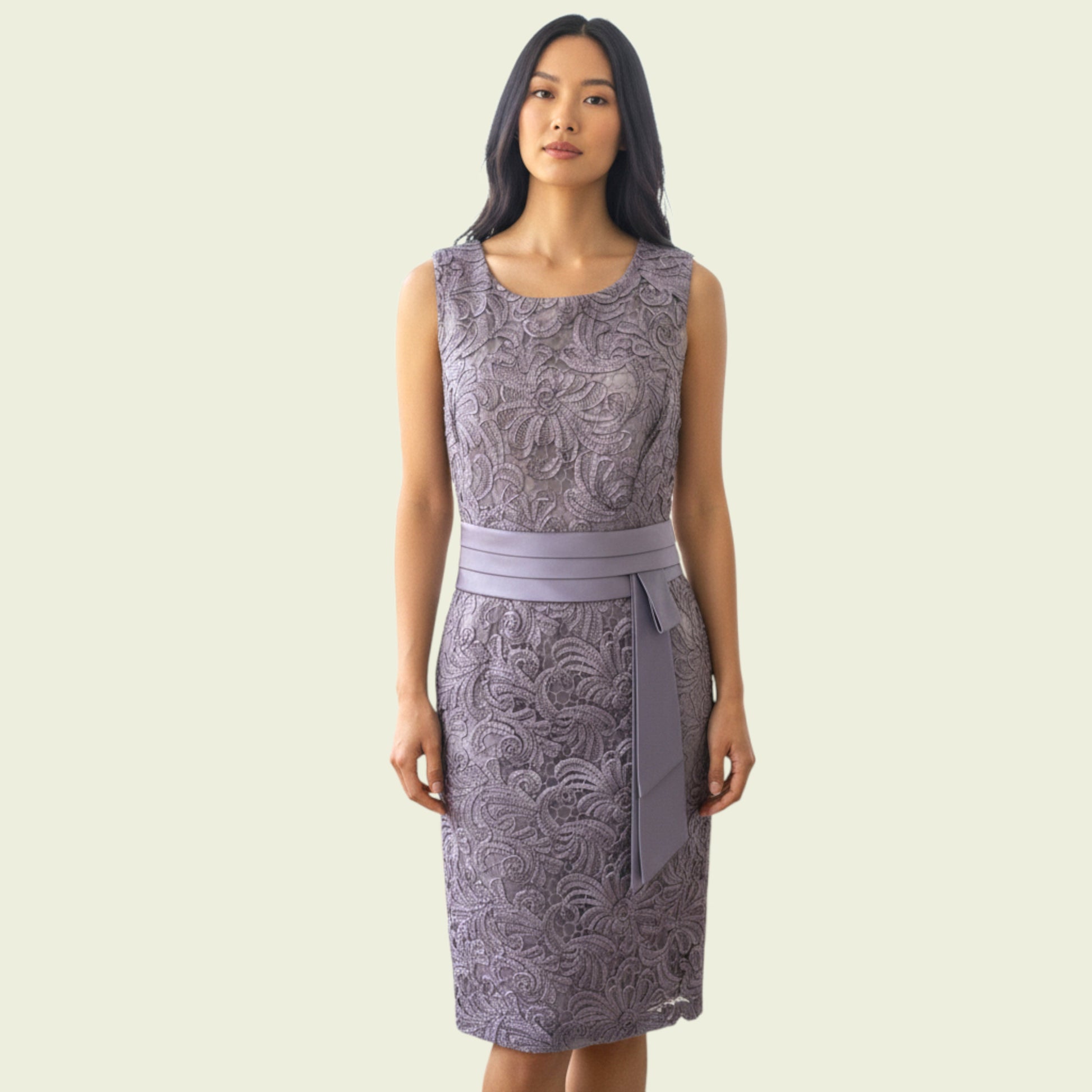 Woman wearing a patterned dress with a belt on a plain background