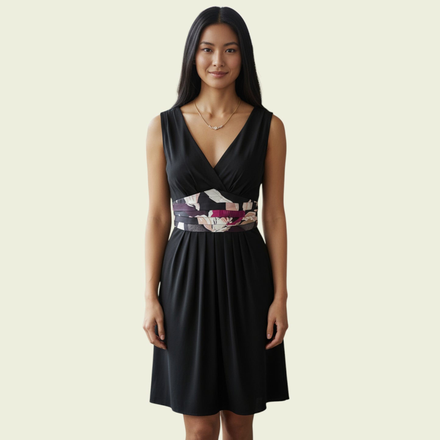 Woman wearing a black dress with a floral belt on a beige background