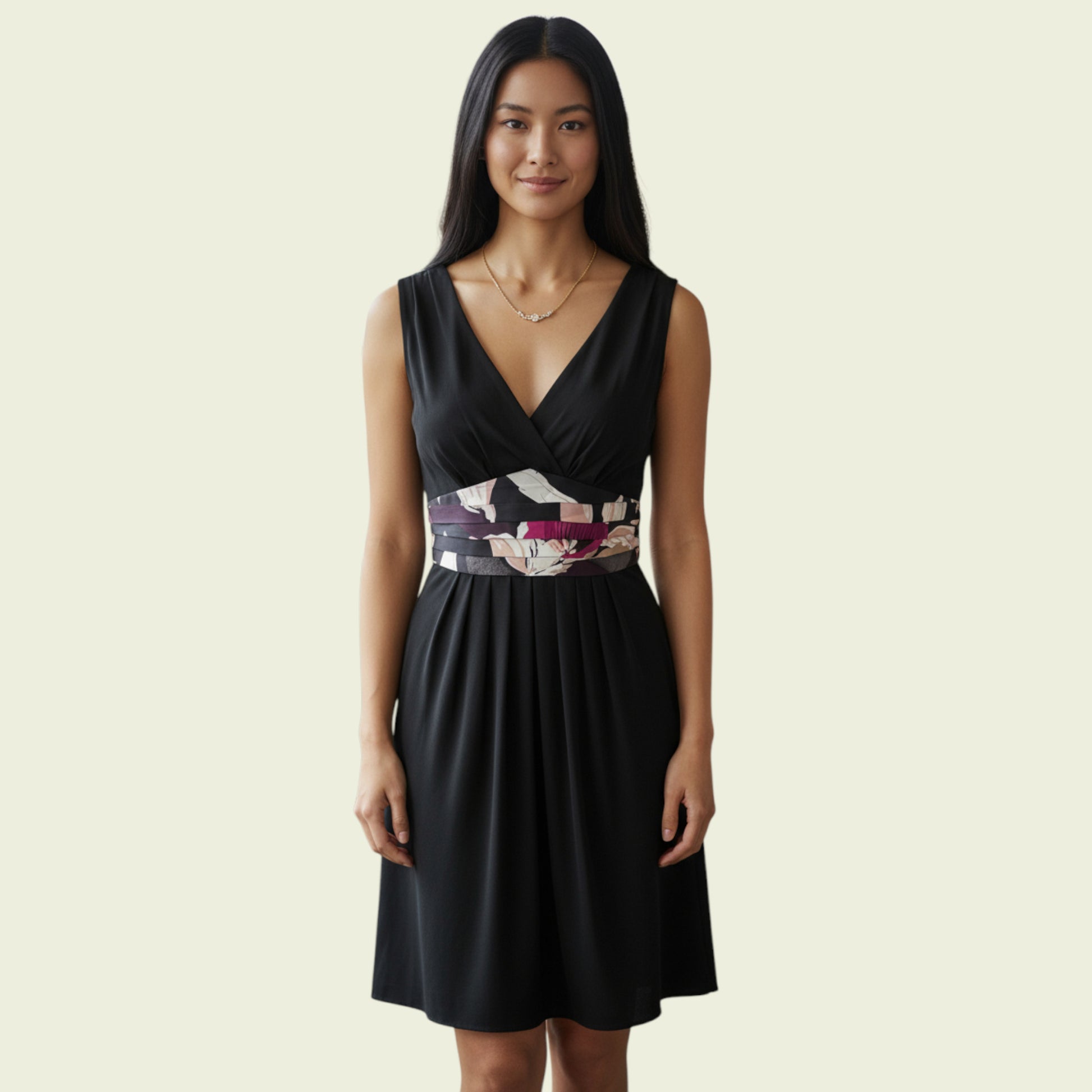 Woman wearing a black dress with a floral belt on a beige background