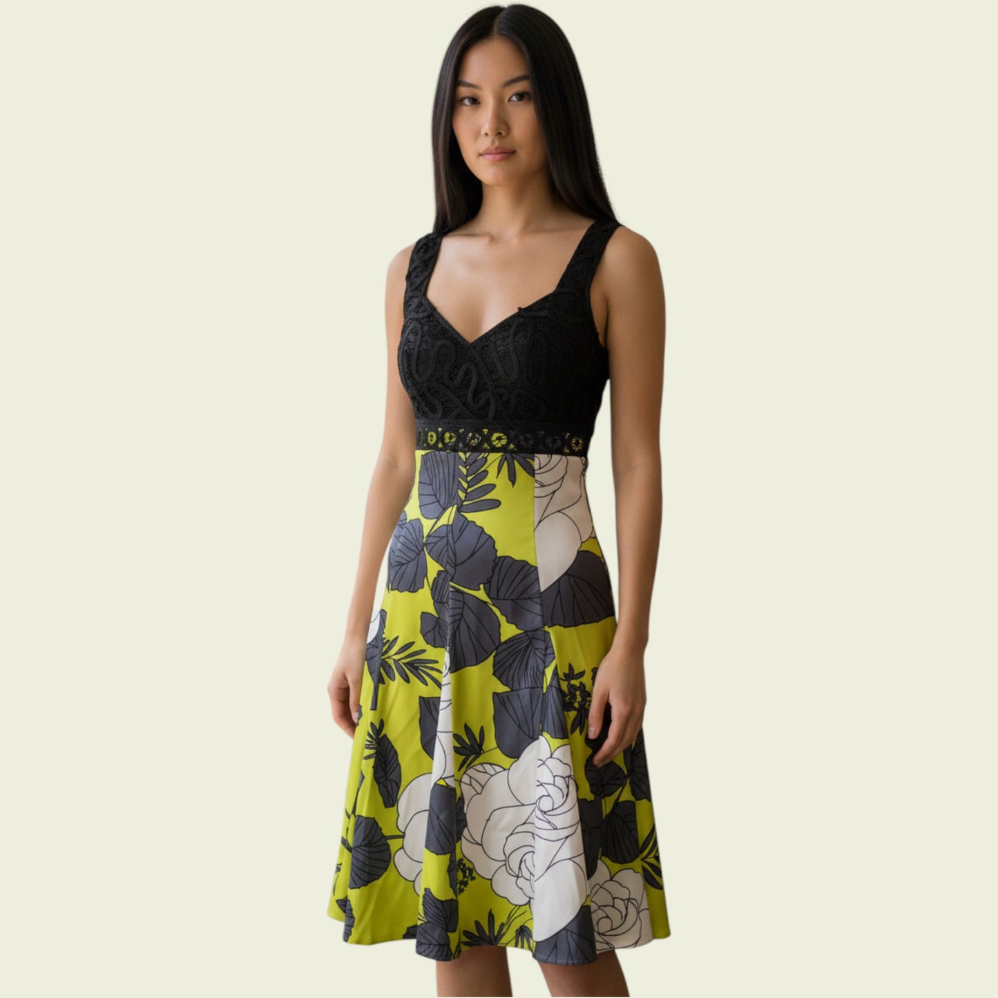 Woman wearing a black and green floral dress on a beige background