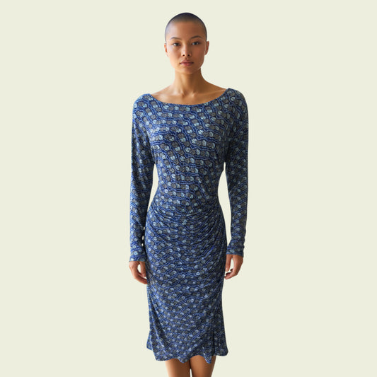 Woman wearing a blue patterned dress on a beige background