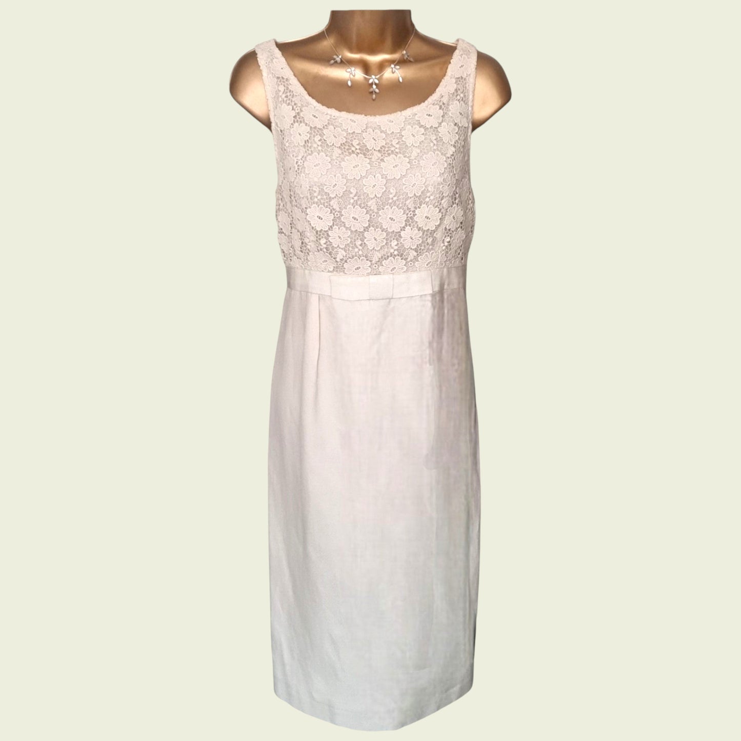 Mannequin wearing a cream dress with embroidered bodice on beige background