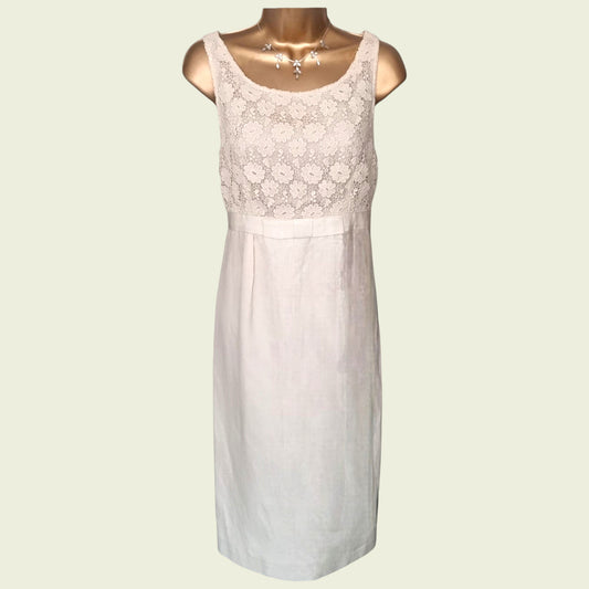 Mannequin wearing a cream dress with embroidered bodice on beige background