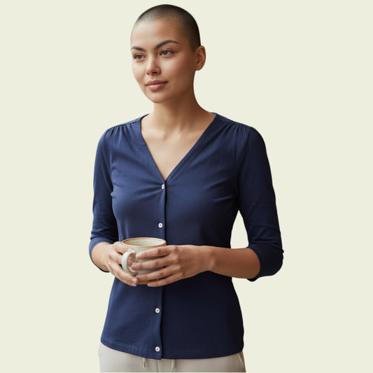 Woman wearing a navy blue cardigan holding a mug against a beige background