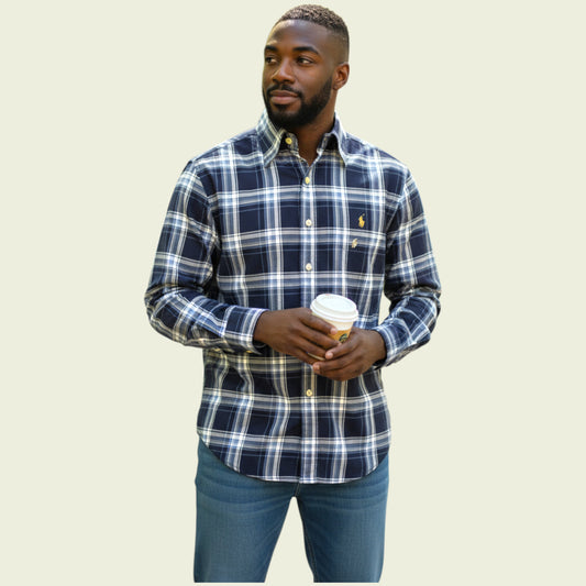 Man wearing a blue plaid shirt holding a coffee cup against a beige background