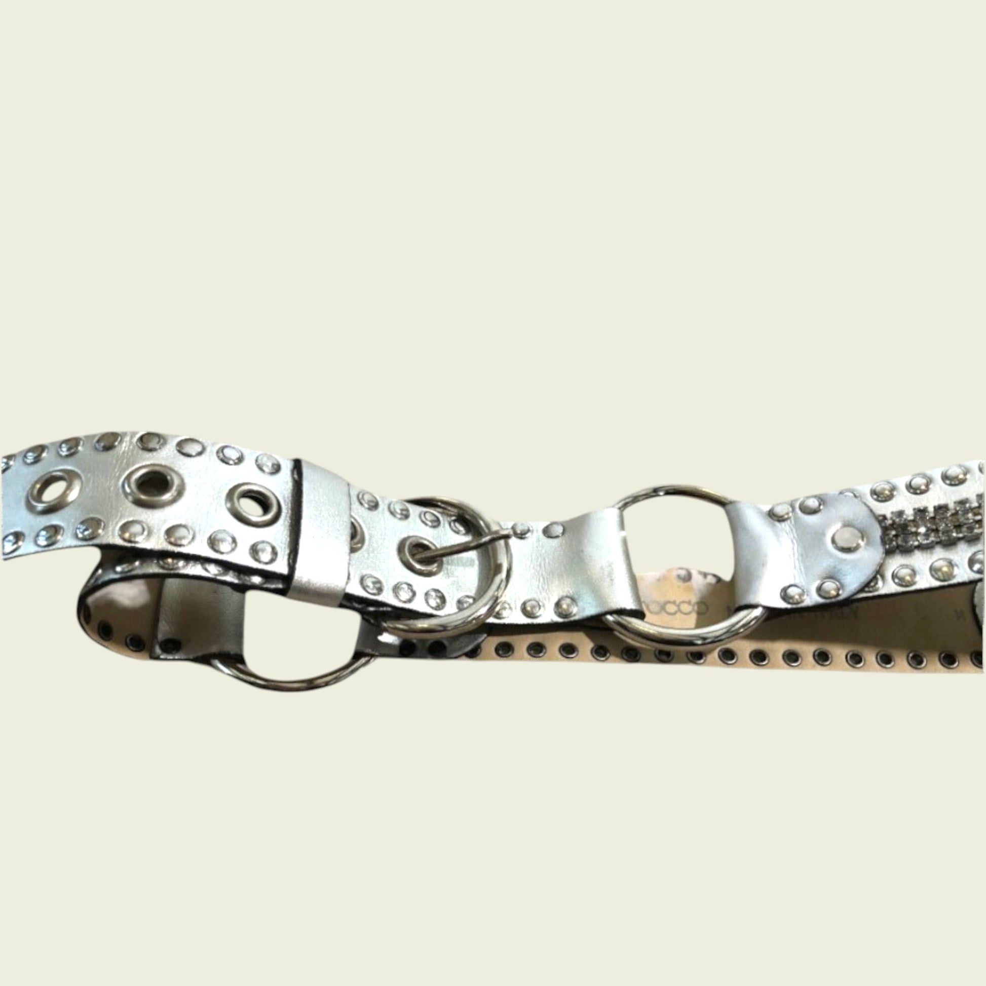 Metallic belt with studs on a beige background