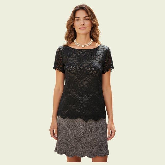 Woman wearing a black lace top and gray skirt on a beige background