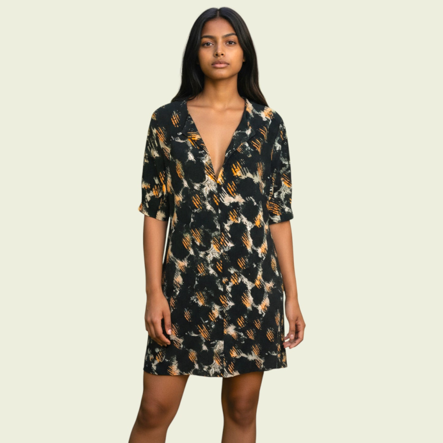 Woman wearing a patterned dress on a beige background