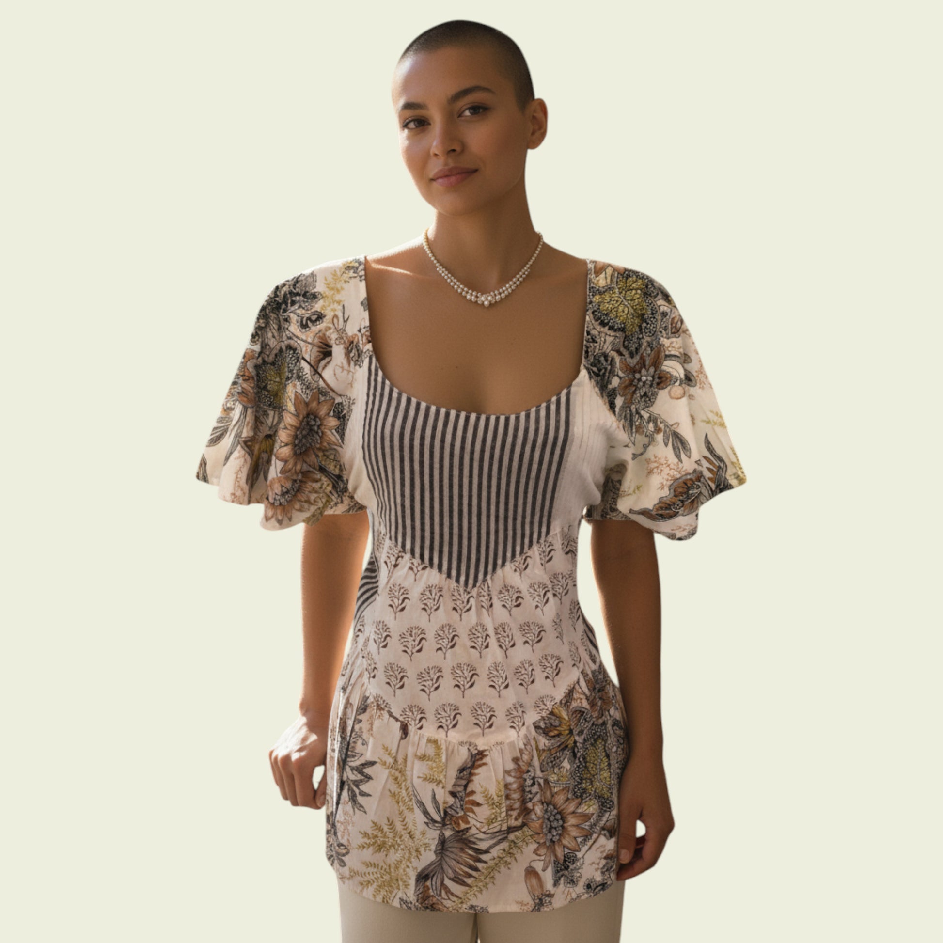 Woman wearing a floral top on a plain background