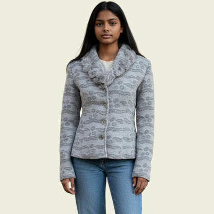 Woman wearing a patterned gray jacket on a beige background