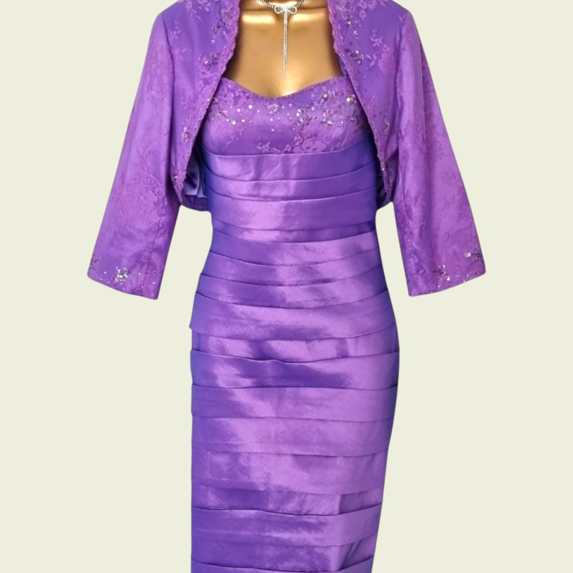 Purple dress with matching jacket on a mannequin against a beige background