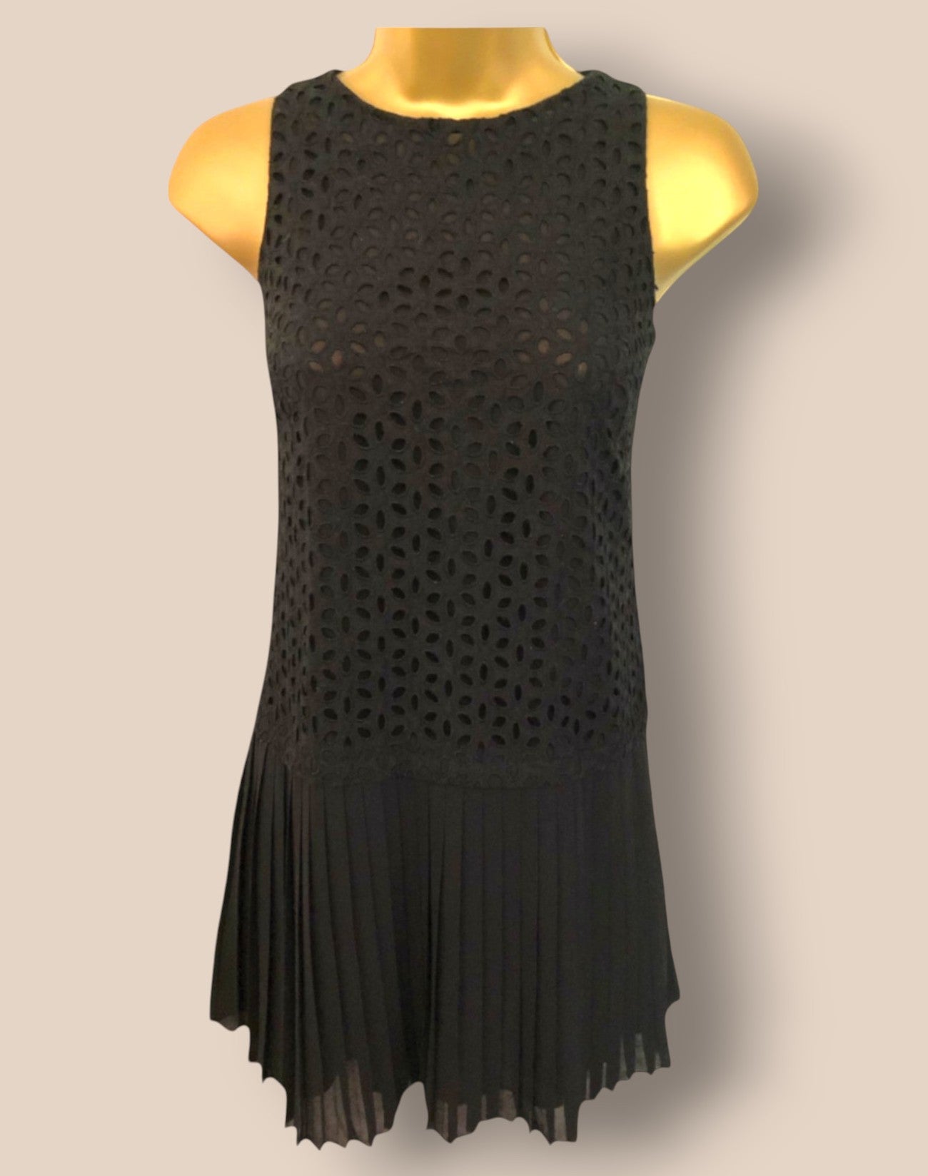 Black sleeveless dress on a mannequin against a beige background