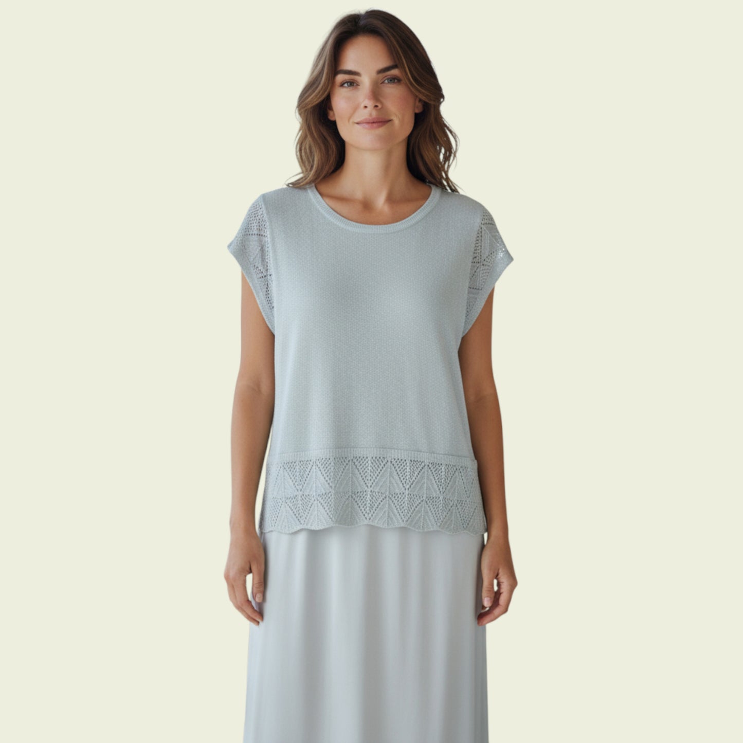 Woman wearing a light green dress with lace detail on a beige background