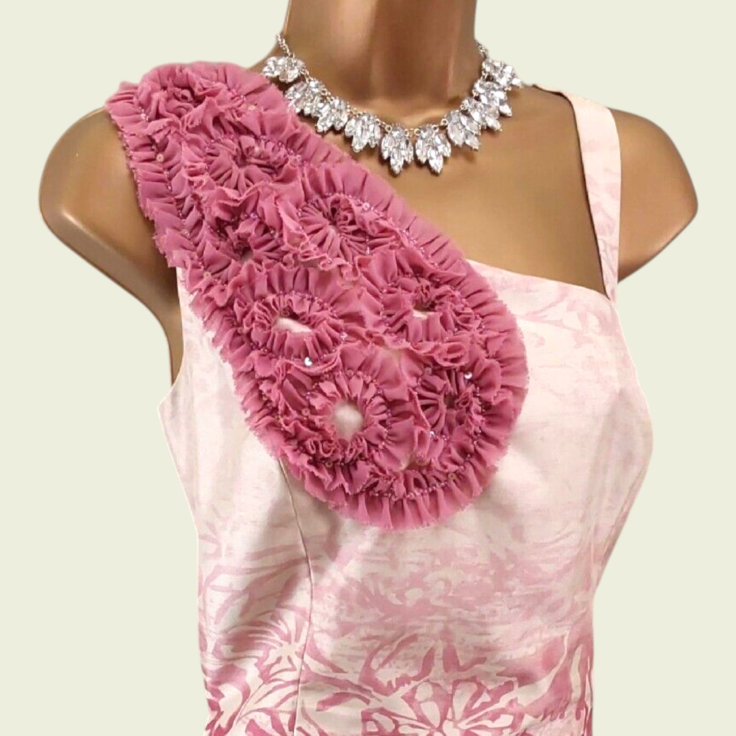 Mannequin with pink and cream floral corsage on beige background