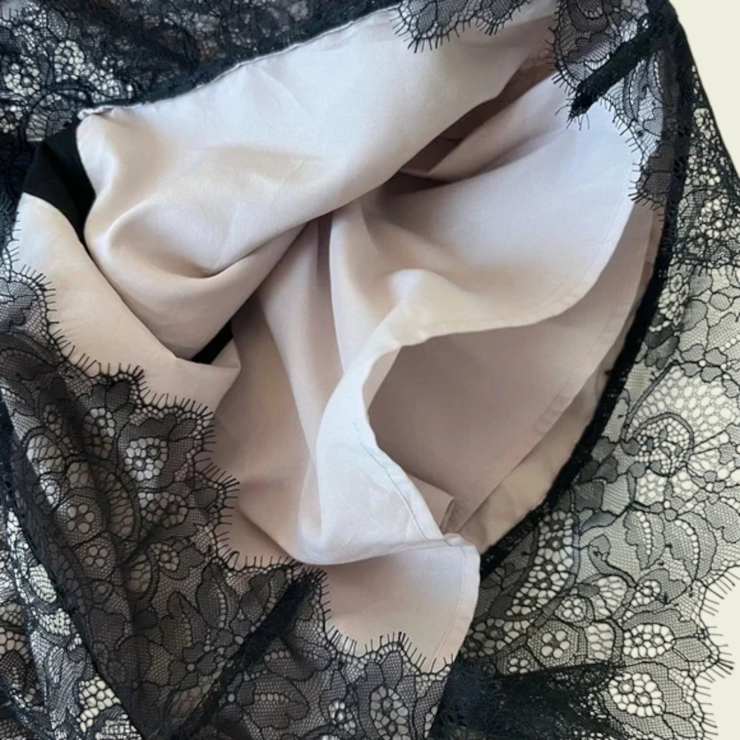 Close-up of a black lace garment with a beige fabric interior.