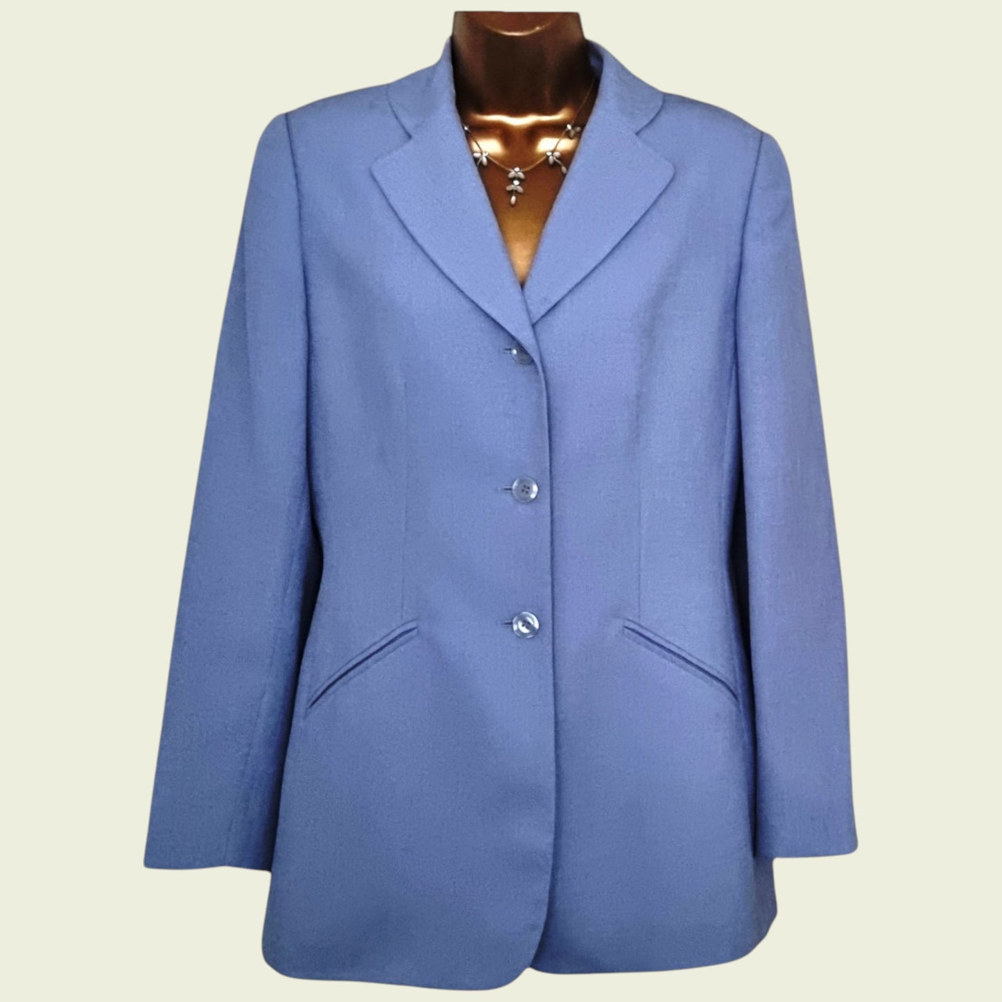 Blue blazer on a mannequin against a beige background