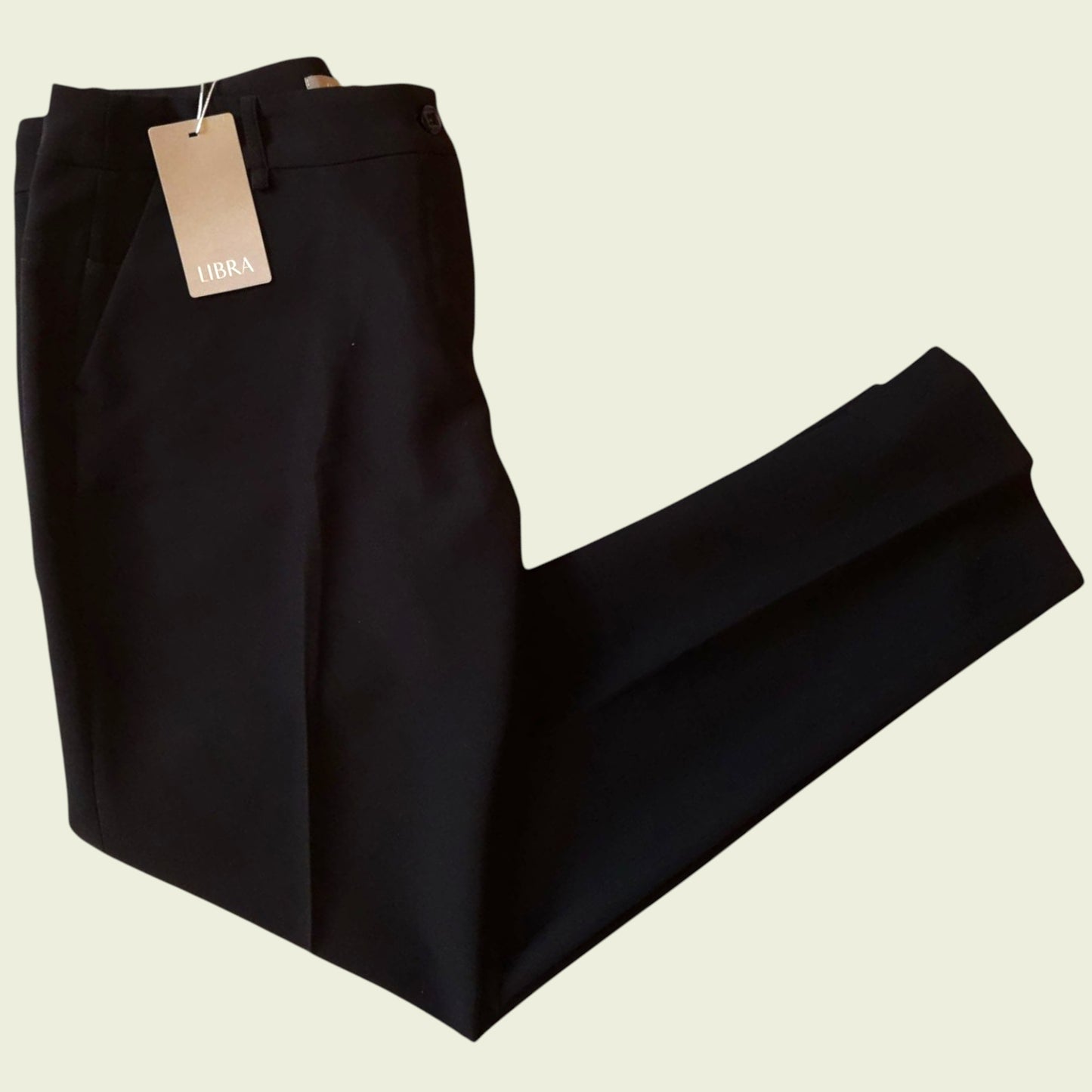 Black pants with a tag on a beige background