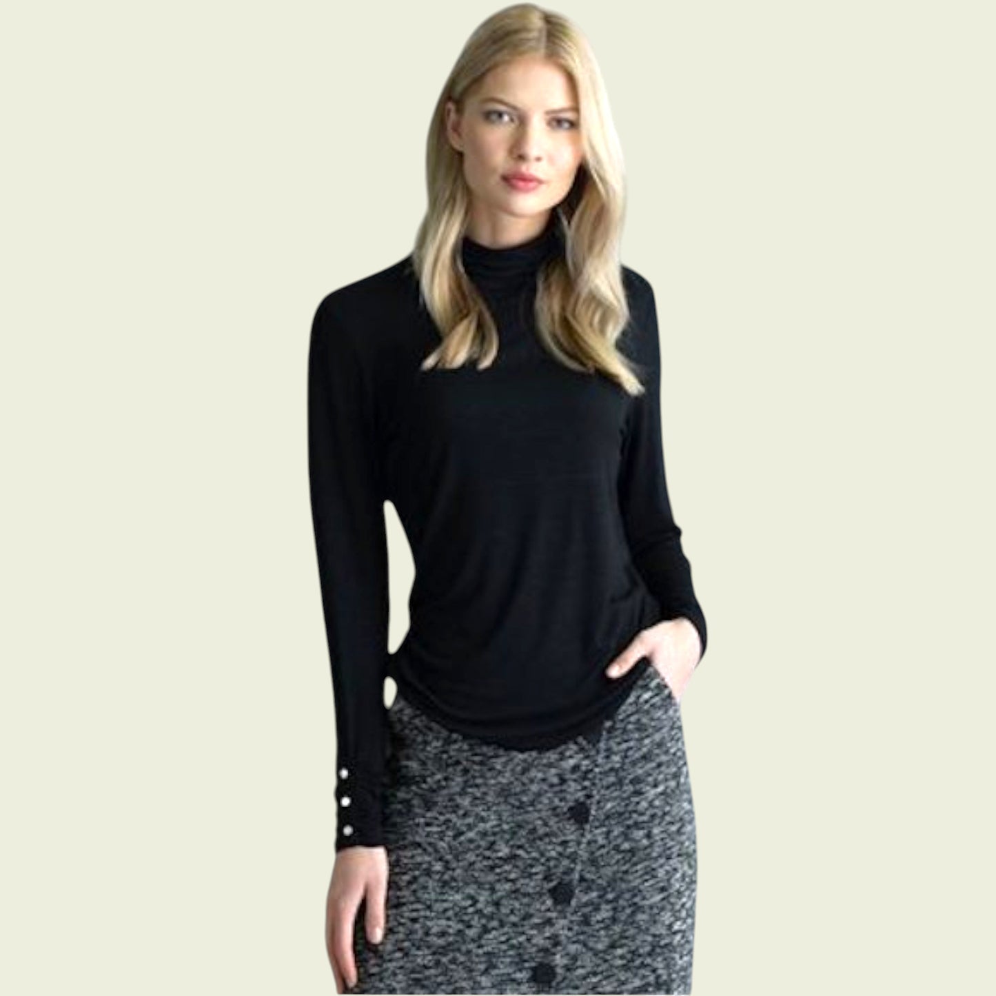 Woman wearing a black long-sleeve top with cut-out design on a beige background