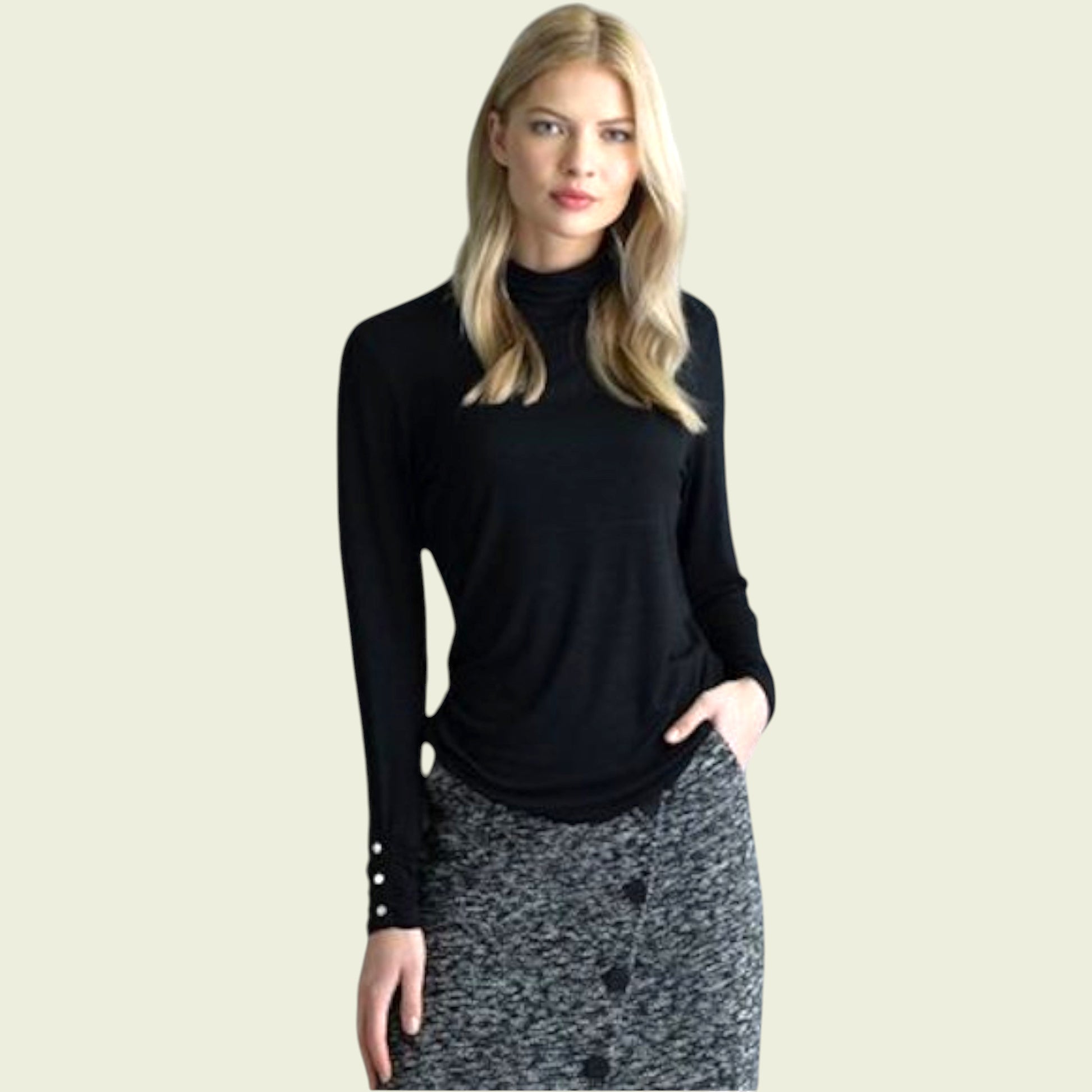 Woman wearing a black long-sleeve top with cut-out design on a beige background