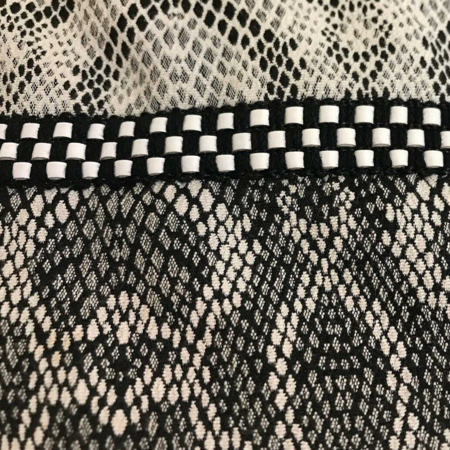 Close-up of a black and white patterned fabric with a checkered border.