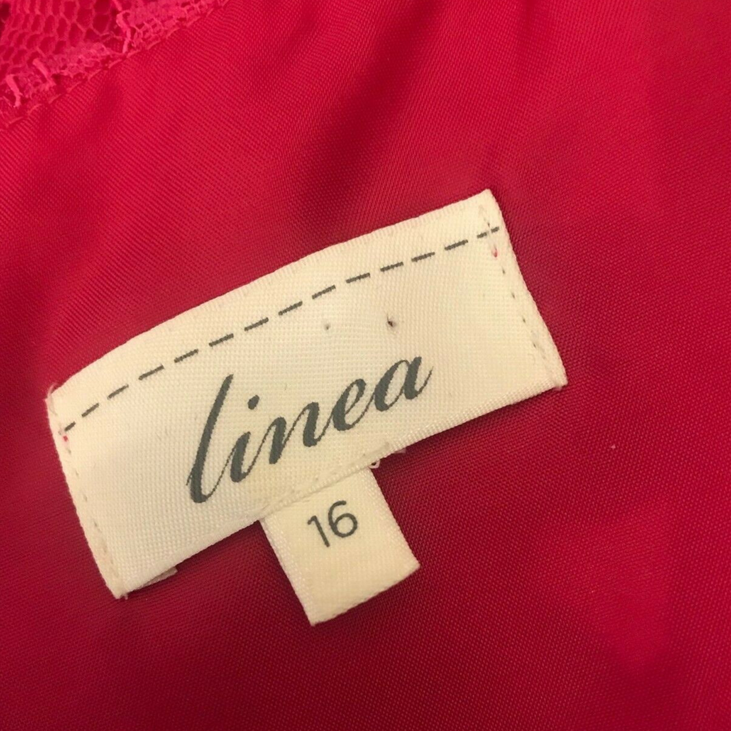 Clothing label showing LINEA and size on pink background