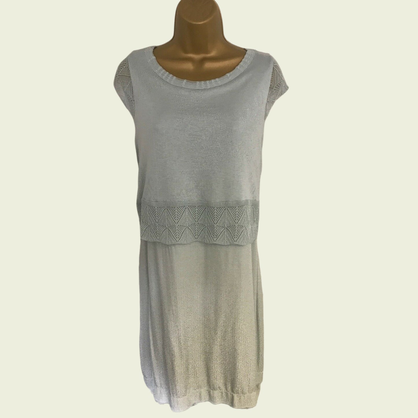 Light green sleeveless dress on a mannequin against a plain background