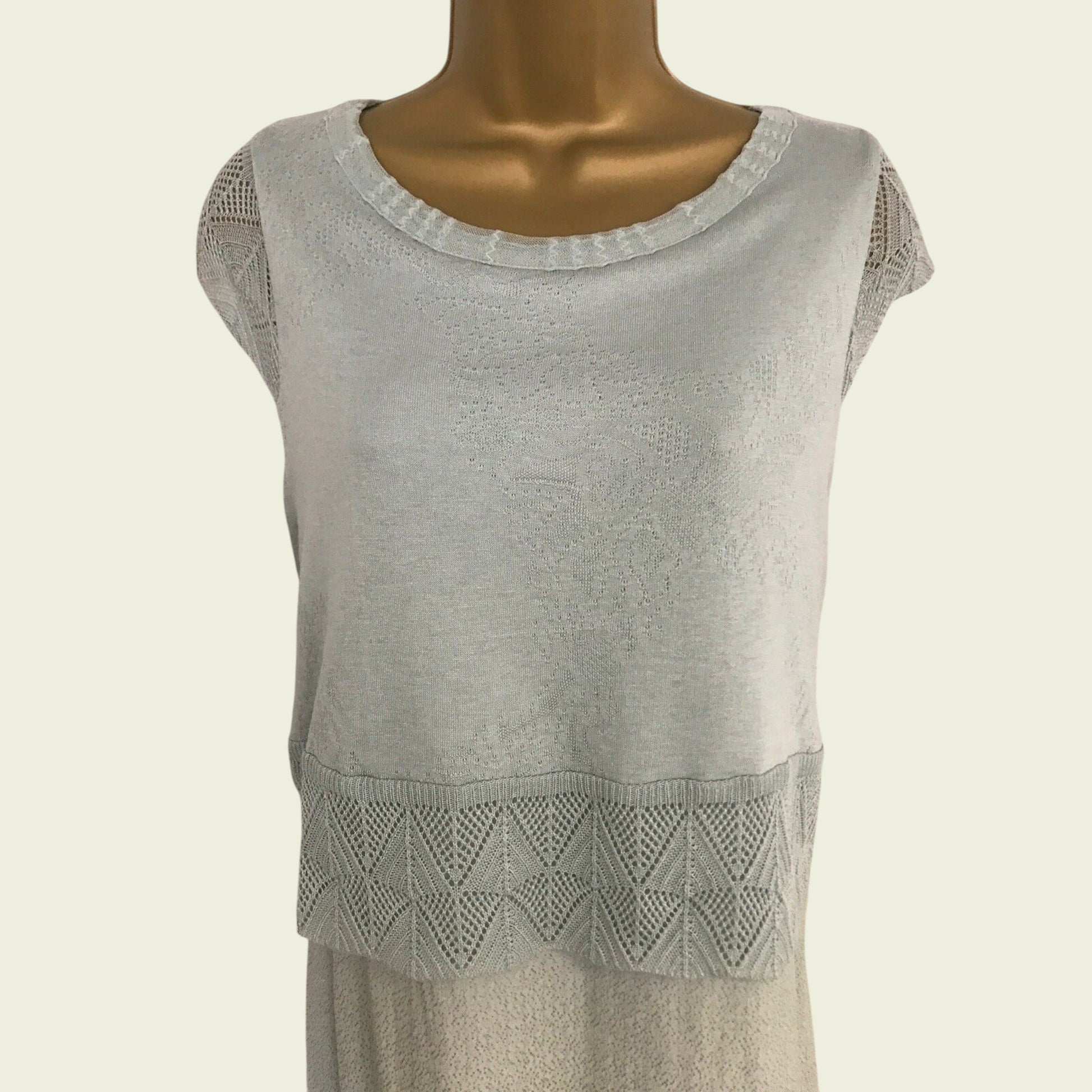 Greens sleeveless top with lace detail on a mannequin against a beige background
