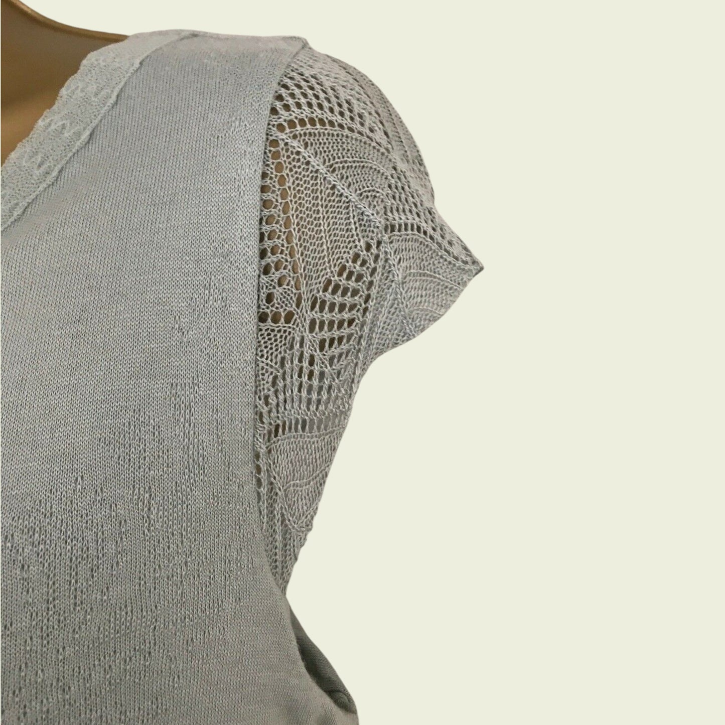 Green dress with lace detailing on a beige background