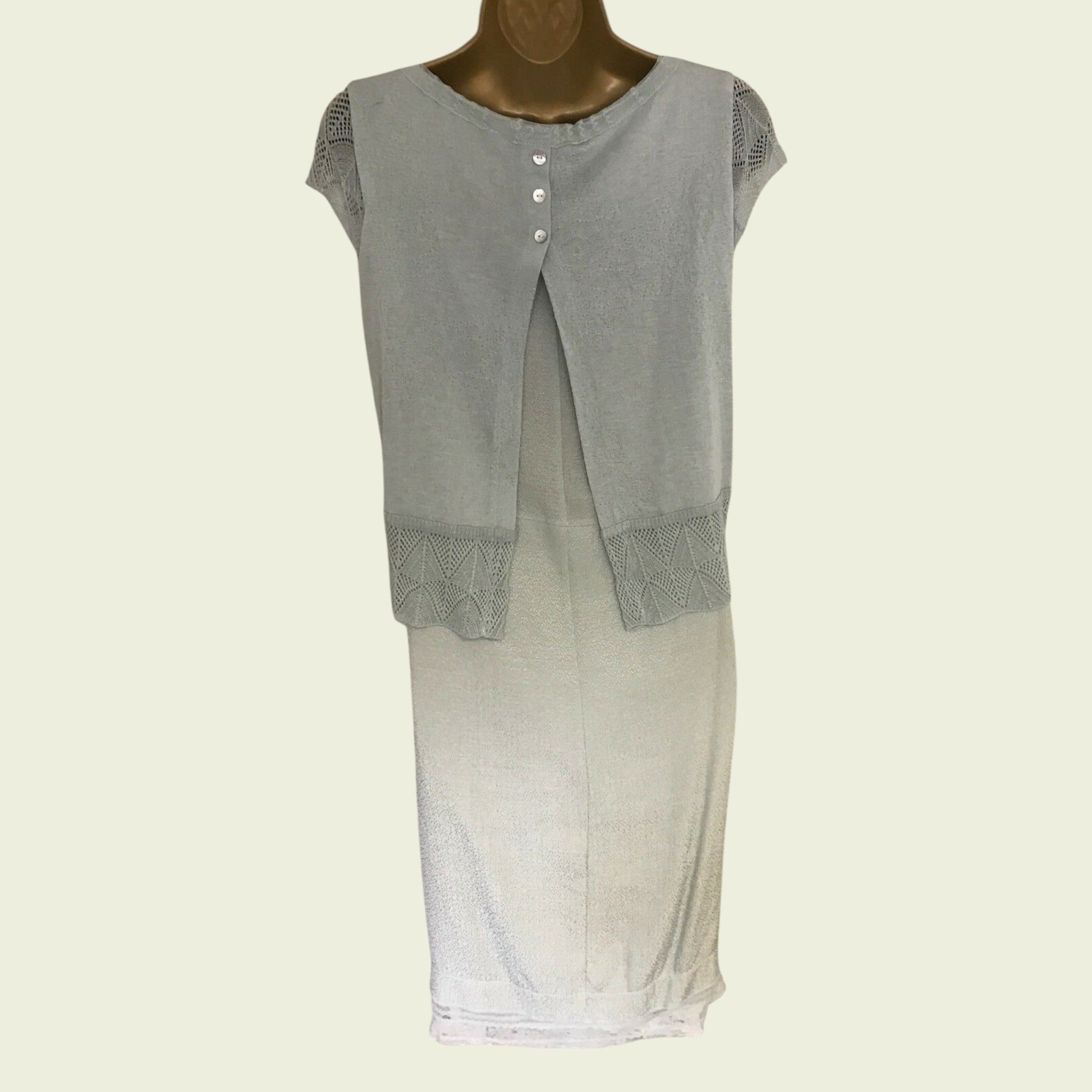 Green sleeveless top with textured trim on a mannequin against a white background