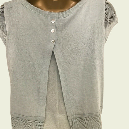 Light green sleeveless top with button details on a beige background